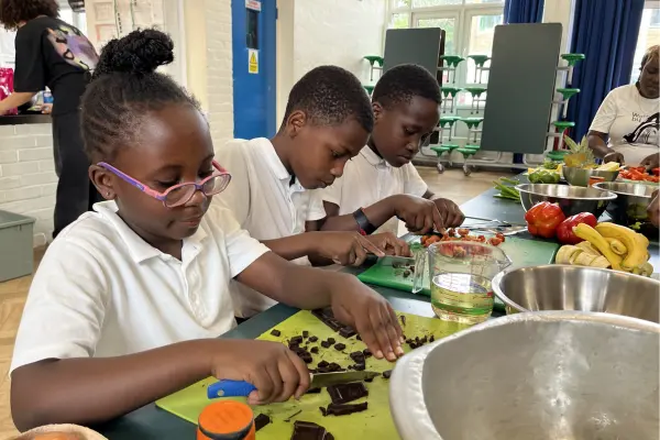 young people at an eat club food education and cooking course cooking at a school in Hackney